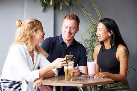 Group of multi-ethnic friends enjoying delicious cocktails in cafe