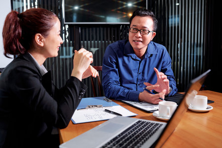 Asian business executives disucssing new project at daily meeting