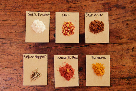 Image of signed papers and handful of spices and herbs lying on wooden table