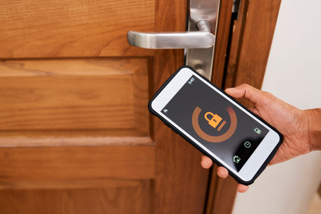Close-up of woman controlling the security of her house with mobile app on smartphone, she locking...