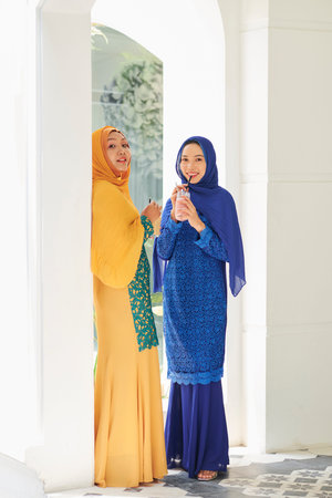 Muslim women holding smoothies while waiting for guests