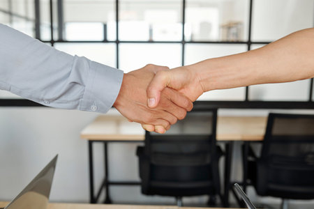 Firm handshake of designer and project manager after successful daily meetingの写真素材