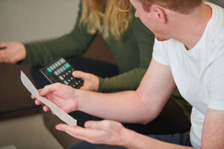 Young couple discussing bills and calculating expencesの写真素材