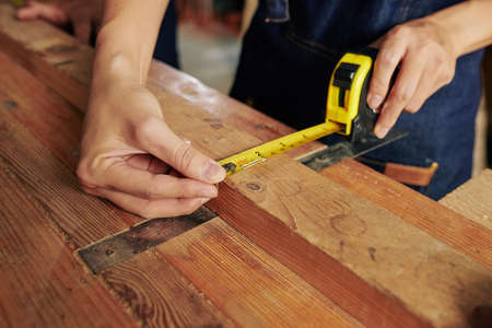 Close-up image of carpenter measuring width of wooden plankの写真素材