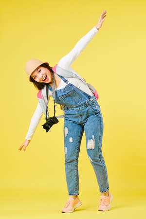 Happy excited female tourist with digital camera dreaming of flying by planeの写真素材