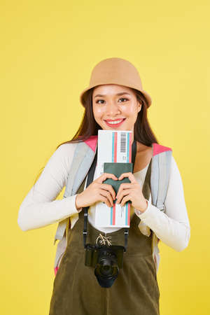 Lovely smiling young Vietnamese traveler in panama hat holding international passport and boarding passの写真素材