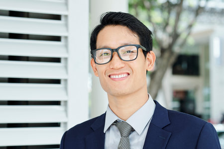Portrait of happy young Asian entrepreneur with beautiful toothy smile looking at camera