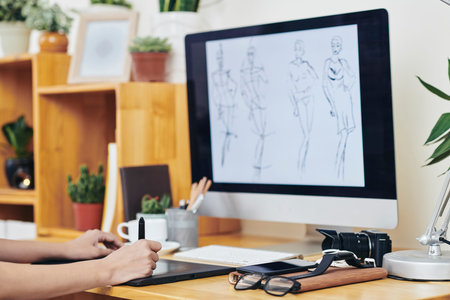 Graphic designer using graphic tablet when drawing fashion illustration for his portfolio at office...