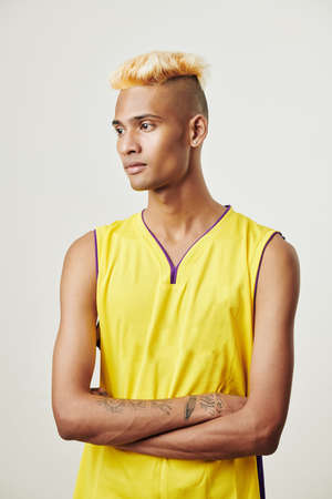 Portrait of young pensive slim Black basketball player folding arms and looking away, isolated on whiteの写真素材