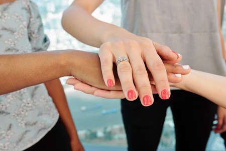 Hands of young female entrepreneurs stacking hands to express unity and cooperationの写真素材