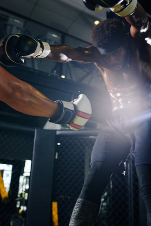Muay Thai boxer delivering a stomach punch and knocking the wind out of opponent suring the match