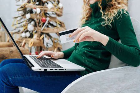 Cropped image of young woman using credit card for online shopping on Christmas saleの写真素材