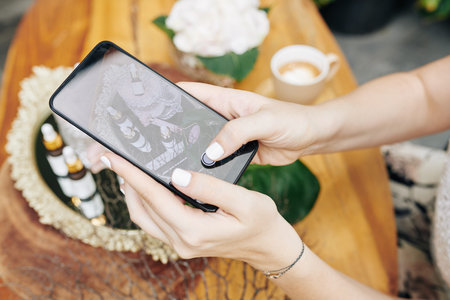 Hands of cosmetics brand owner taking photos of new products and uploading on social media or online...