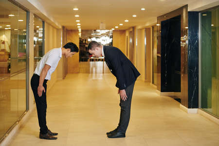 Multi-ethnic business colleagues bending forward to express respect and greet each otherの写真素材