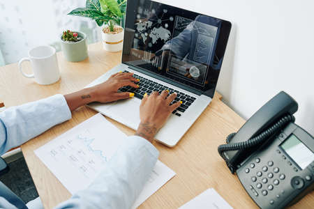 Hands of business lady working on laptop and creating annual financial report for her companyの写真素材