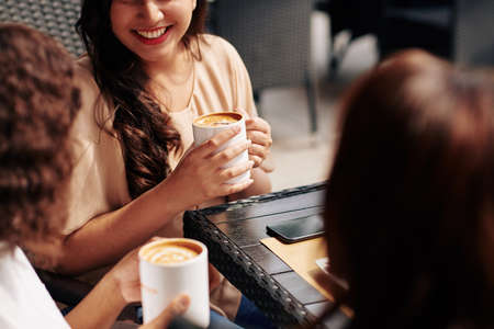 Cropped image of female friends meeting in coffeeshop and discussing news and gossipsの写真素材