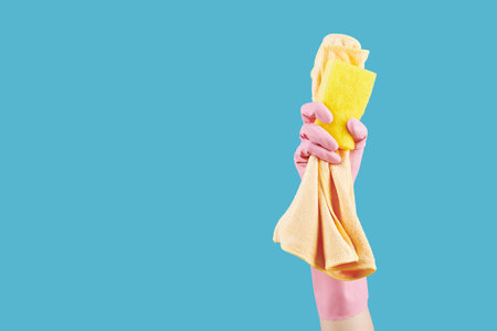 Hand of housewife showing kitchen soap and microfiber cloth she is using for cleaning the houseの写真素材