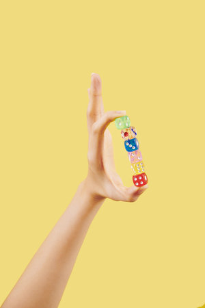 Hand with transparent colorful dices on light yellow backgroundの写真素材