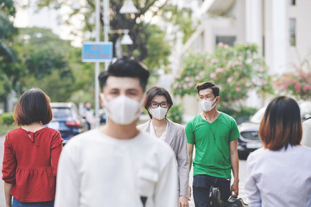 People walking in public space with pmedical masks on to protect themselves from coronavirus...