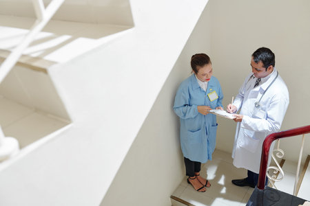 Chief physician signing document for his female coworker