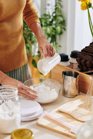 Woman mixing dry ingredients for soap or bath bomb in glass bowlの写真素材
