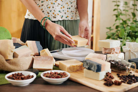 Woman cutting handmade soap in pieces and packing it for customersの写真素材
