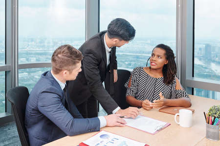 Business executives discussing terms of contract at meeting, businesswoman defending her point of viewの写真素材