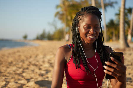 Pretty positive female jogger making video call to her trainer after workoutの写真素材