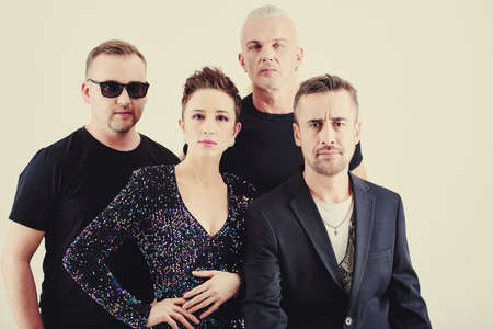 Group of music band members posing in concert clothes before performanceの写真素材