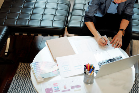Professional UX designer working on mobile application mockup when sitting at cafe table, view from aboveの写真素材