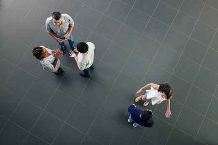 Business people talking in office hall, discussing projects and ideas, view from aboveの写真素材