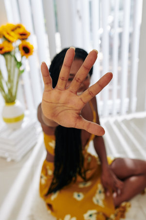 Young woman outstretching hand towards camera, focus on foreground