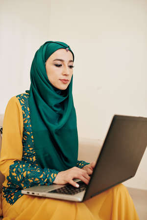 Serious muslim businesswoman in hijab working from home during coronavirus outbreakの写真素材