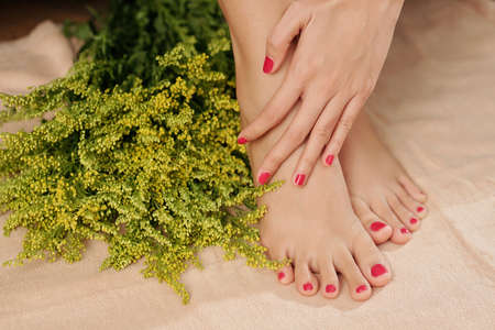 Woman touching soft tender skin of her feet after getting pedicure in spa salonの写真素材