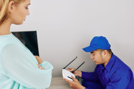 Service worker installing dual band wi-fi router in apartment of young woman