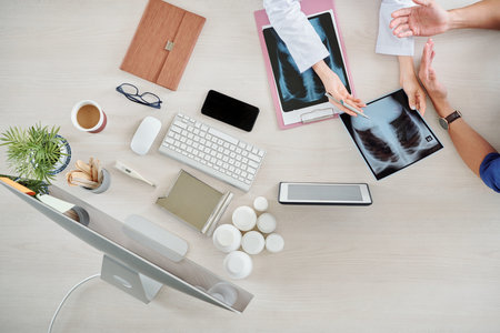 Hands of doctor showing patient his chest x-ray and discussing prescrioption and medical treatment he should getの写真素材