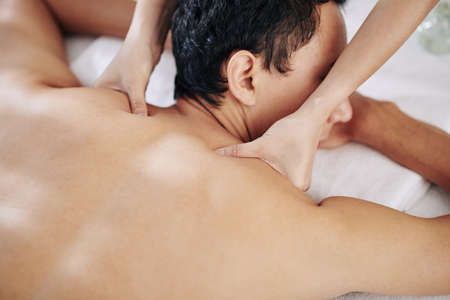 Close-up image of young woman massaging neck and shoulders of clientの写真素材
