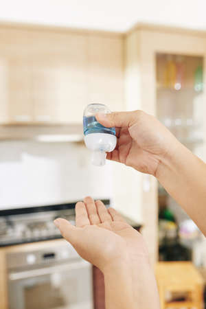 Close-up image of woman applying anti-bacterial hand gel after touching surfacesの写真素材