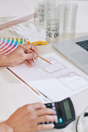 Close-up image of construction engineer drawing blueprint for the project he is working onの写真素材