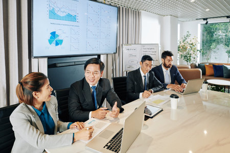 Company managers having meeting at big office table and discussing plans of company developemnt...