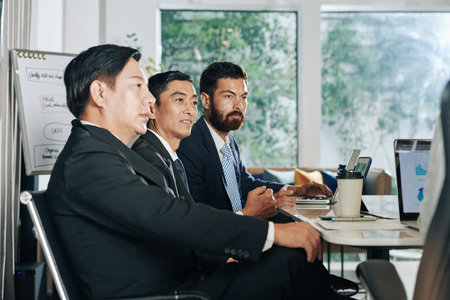 Group of investors listening to project presentation of business person at meeting