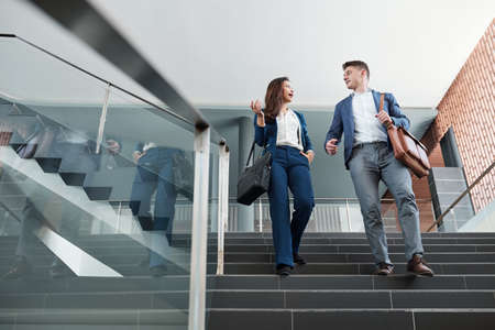 Business people walking down the stairs and discussing fresh ideas after workの写真素材