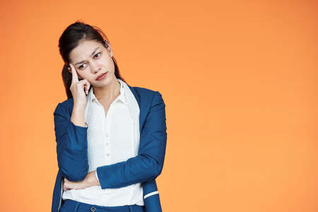 Frowning young female enterpreneur thinking how to run business in times of coronavirus crisisの写真素材