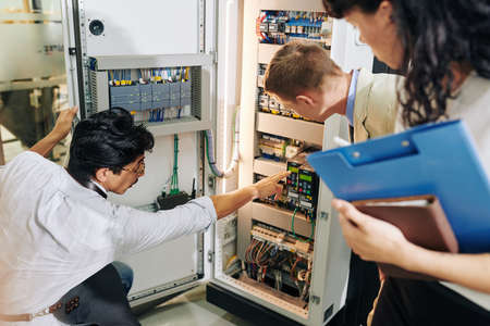 Small factory owner showing control locker to inspectorsの写真素材