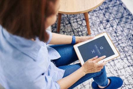 Woman using application on tablet computer to order home service