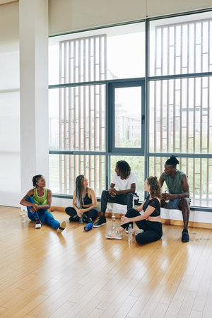 Multi-ethnic group of dancers discussing upcoming concert after training in dance class