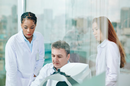 Group of serious ophthalmology clinic specialists discussing results of ocular fundus examinationの写真素材