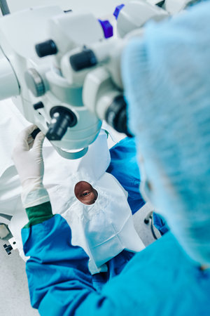 Surgeon operating eye of patient and using surgical microscope at the operating room
