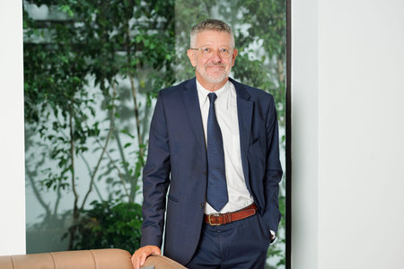 Happy successful senior businessman in glasses smiling at camera