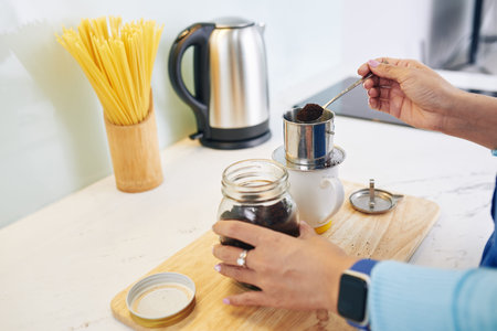 Hands of woman making Vietnamese style coffee at home in the morningの写真素材